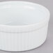 A white ceramic fluted souffle bowl with a white rim.