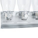A Zevro silver triple dry food dispenser on a metal stand with clear plastic canisters.