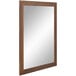 A BrandtWorks mirror with a wooden frame and brown trim.