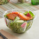 A salmon salad in a Stalk Market clear PLA salad bowl with a fork.