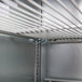 A metal shelf with white rods inside a Beverage-Air black back bar refrigerator.