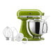 A green KitchenAid Artisan stand mixer with a silver bowl and whisk attachment.