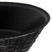 A black plastic round serving basket with a handle.