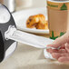 A hand using a Tork Xpressnap dispenser napkin to wipe a counter.