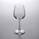 A clear Libbey Vina tall wine glass on a white surface.
