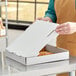 A woman opening a white Choice pizza box.