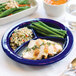 A Tuxton cobalt china plate with chicken, rice, and green beans on it.
