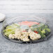 A WNA Comet clear plastic tray with a dome lid over a variety of vegetables.