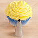 A cupcake with yellow frosting piped on top using an Ateco open star piping tip.