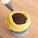A person using an Ateco open star piping tip to put frosting on a cupcake.