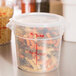 A translucent plastic container with a lid holding spiral pasta.