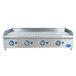 A Globe stainless steel countertop gas griddle with blue knobs on a large rectangular metal surface.