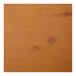 A close-up of a knotty pine table top with a brown stain.