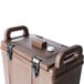 A brown plastic cooler with black handles.
