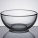 A Libbey clear glass bowl on a reflective surface.