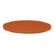 A close-up of a round brown table top with a textured orange surface.