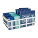 A white Cal-Mil metal condiment organizer with glass jars full of blue and white condiment packets.