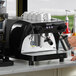 A woman pouring coffee into a Gaggia RUBY Pro espresso machine.