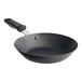 A Vollrath black carbon steel fry pan with a black silicone handle.