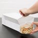 A hand putting pasta into a Duro paper bag.
