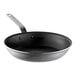 A close-up of a Vollrath Wear-Ever black frying pan with a plated handle.