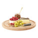 A Cal-Mil round oak wood serving board with cheese, grapes, and nuts on it.