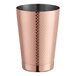 A copper Barfly cocktail shaker with a diamond lattice design on a table.