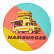 A white food truck with a yellow and black logo of a hamburger.