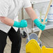 A person in green Ansell AlphaTec gloves cleaning a mop.