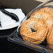 A Cal-Mil clear plastic bakery tray holding bagels.