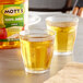 Two glasses of Mott's apple juice on a counter.