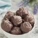 A bowl of chocolate truffles with a sprinkle of salt on top.