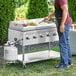 A man cooking food on a Backyard Pro stainless steel outdoor grill with a griddle.