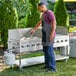 A man grilling food on a Backyard Pro stainless steel outdoor grill.