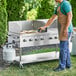 A man cooking food on a Backyard Pro stainless steel outdoor grill.