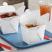 Two Emperor's Select white Chinese take-out containers filled with food.