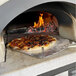 A pizza is cooking in a Chicago Brick Oven on a stationary stand.