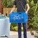 A man carrying a blue Choice vented collapsible crate.