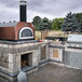 A Chicago Brick Oven countertop pizza oven with a copper vein finish on a patio.