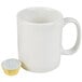 A white coffee mug with a gold foil Ateco mini baking cup inside.