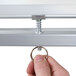 A hand adjusting the height of a Luxor double-sided whiteboard stand.