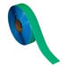 A roll of blue Superior Mark safety tape with green stripes.