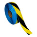 A roll of blue and black striped Superior Mark safety tape with yellow stripes.