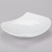 A bone white porcelain peach plate with a curved edge.