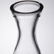 A clear glass carafe with a round neck.