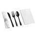 A close-up of a black fork, knife, and spoon set with a white napkin.