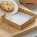 A 10" x 10" single face corrugated pizza pad with a pizza in a box.