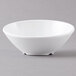 A white San Michele melamine bowl with a slanted edge on a gray surface.