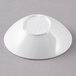 A white slanted melamine bowl on a gray surface.