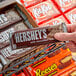 A hand holding a HERSHEY'S King Size Milk Chocolate bar.